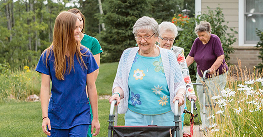 Senior residents enjoying a walk with friendly staff